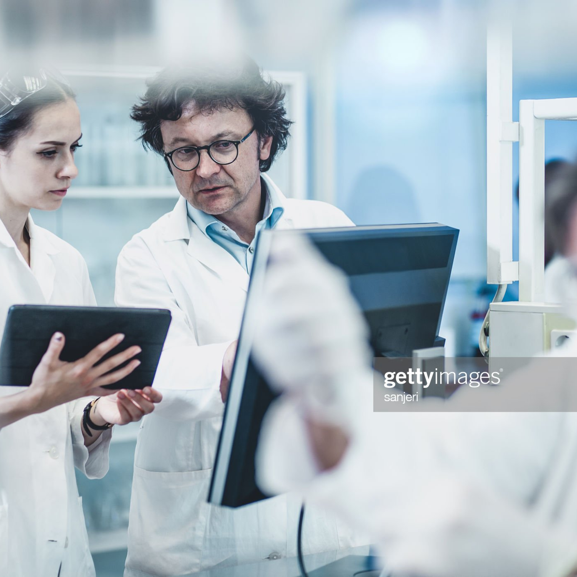 scients in a lab discussing science on an ipad